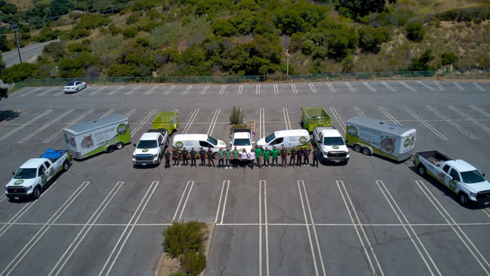 Green Rodent Restoration crews and service vehicles lined up before a day of exterior visits